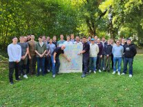 Das Foto zeigt den Jahrgang im Garten der Forstschule. An der Stellwand ist die Herkunft der Teilnehmer veranschaulicht, hier links Ingmar Bube, Klassenleiter und rechts Nils Illerich aus Brandenburg, Teilnehmer mit der weitesten Anreise. 
